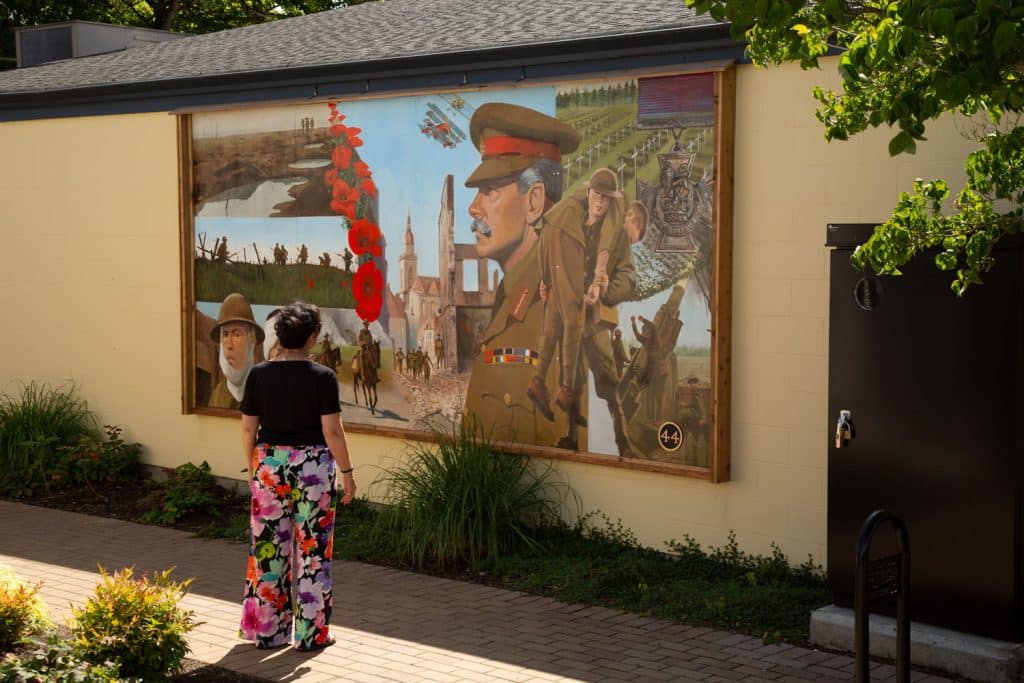 Woman admiring a historical mural.