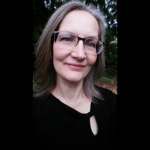 Person with long gray hair outdoors.