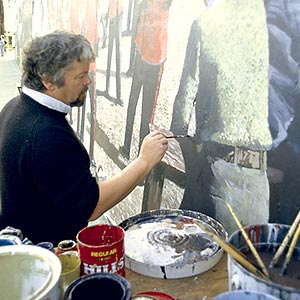 Artist painting a large mural.