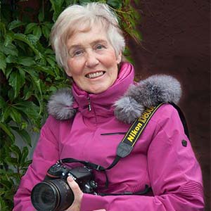 Person in pink jacket with camera