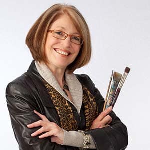 Artist holding paintbrushes confidently.