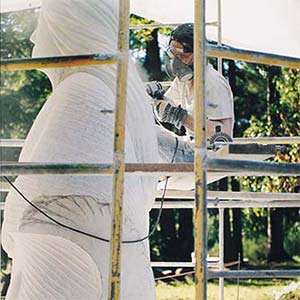 Artist sculpting statue outdoors.