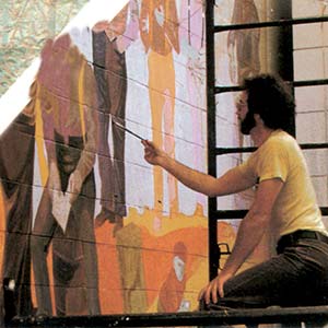 Artist painting mural on wall