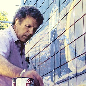 Person painting a mural outdoors.