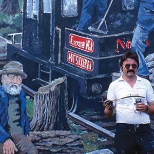 Men near a train mural backdrop.