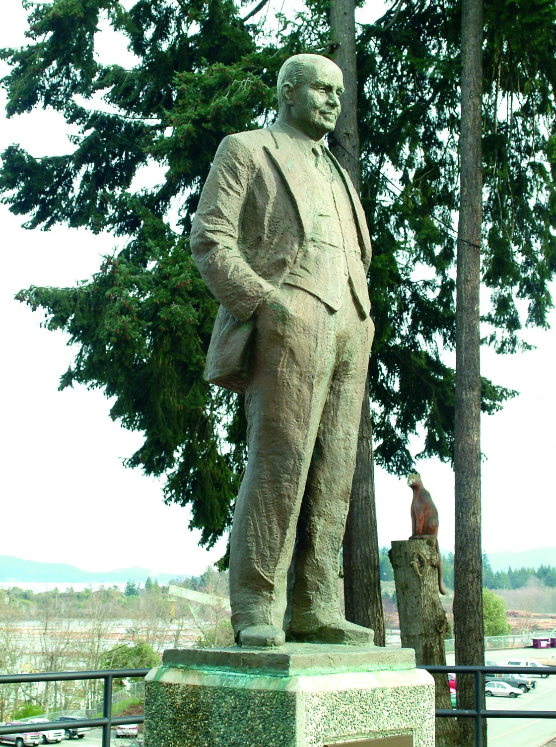 Tall statue among evergreen trees.