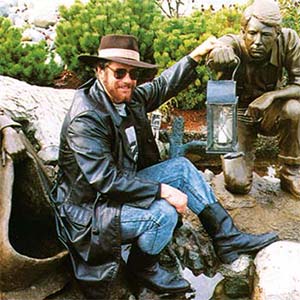 Man posing with statue and lantern.